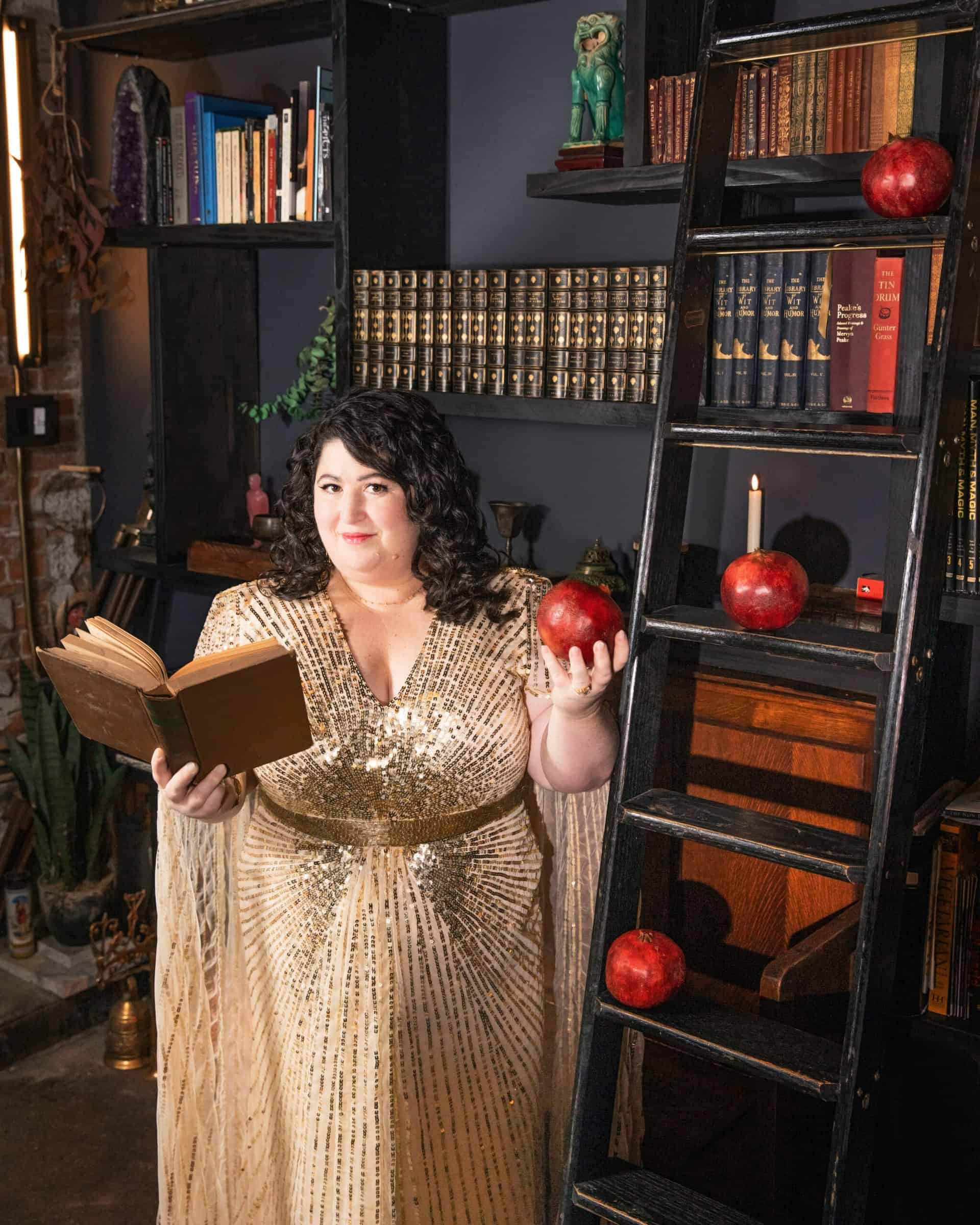 Kara Loewentheil holding a book and a pomegranate.