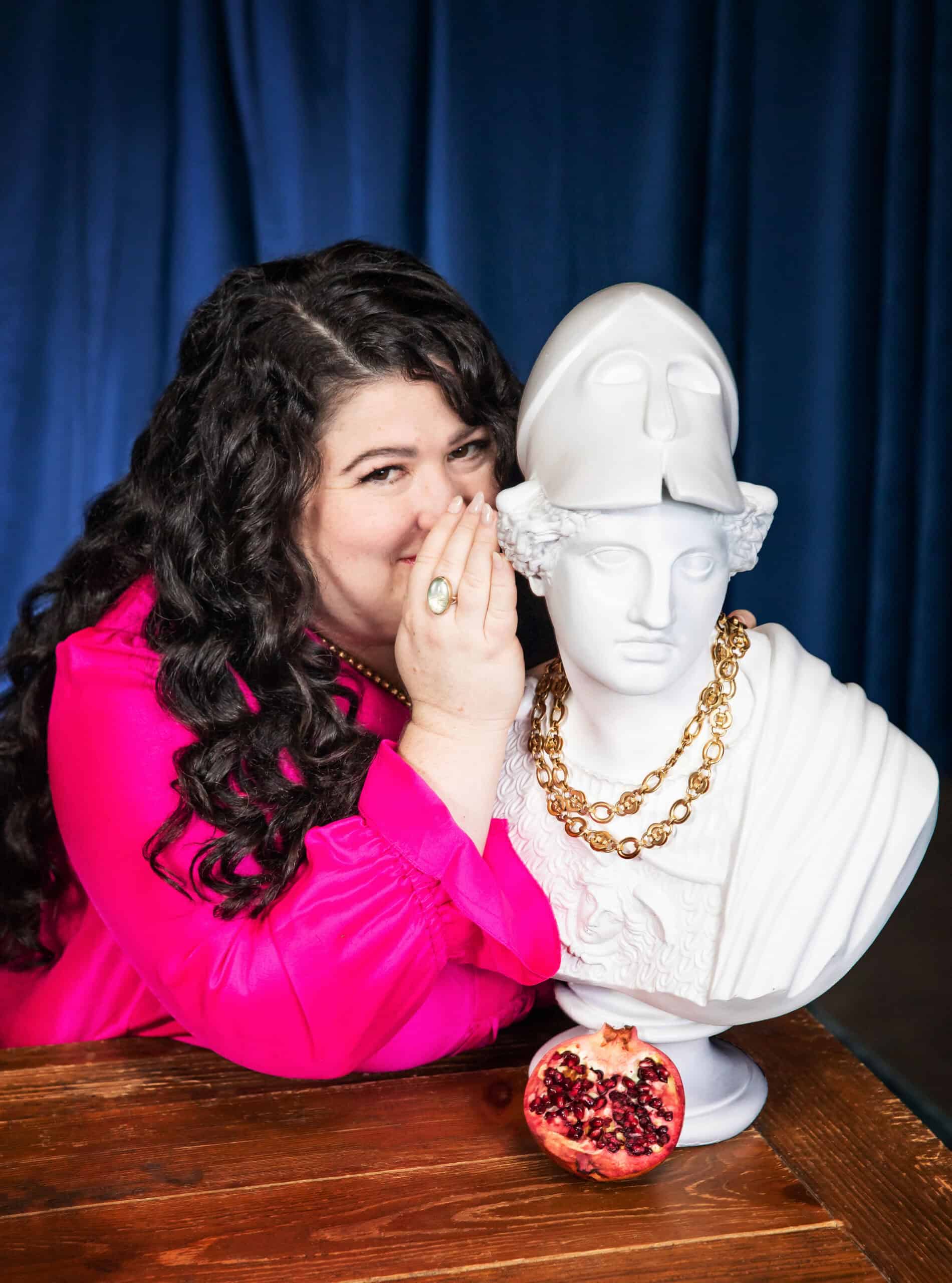 Kara Loewentheil leaning in to whisper to a classical bust